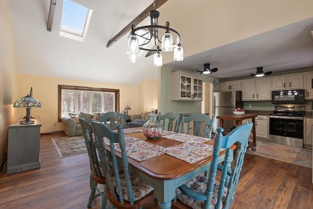 dining room featuring dark hardwood / wood-style floors, lofted ceiling with skylight, and ceiling fan with notable chandelier