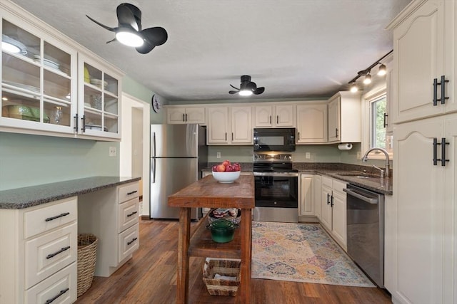 kitchen featuring sink, built in desk, appliances with stainless steel finishes, dark hardwood / wood-style floors, and ceiling fan