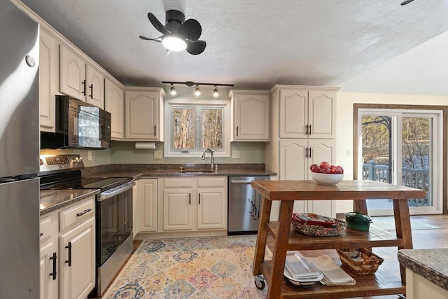 kitchen featuring appliances with stainless steel finishes, sink, ceiling fan, and cream cabinetry