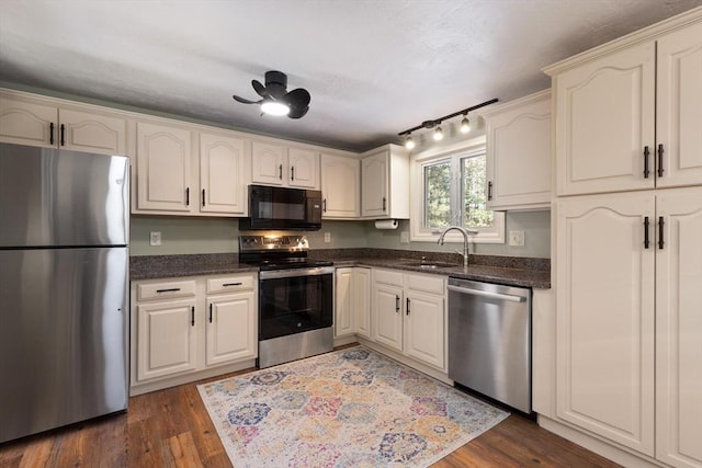 kitchen with ceiling fan, stainless steel appliances, dark hardwood / wood-style flooring, and sink