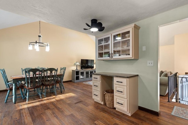 dining room with dark hardwood / wood-style flooring, ceiling fan with notable chandelier, and a textured ceiling