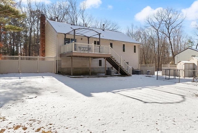 snow covered back of property featuring central air condition unit