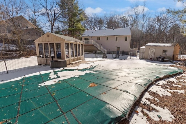 view of pool with a storage shed and a sunroom