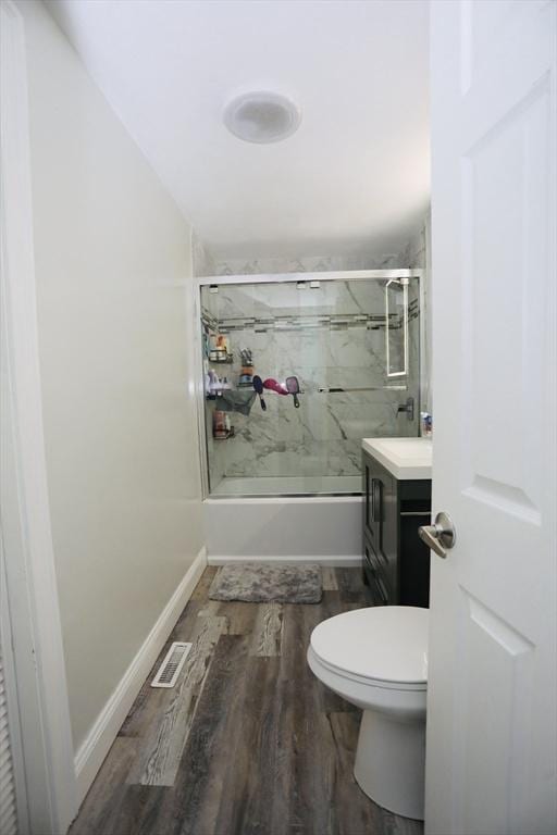 full bath featuring toilet, wood finished floors, visible vents, vanity, and baseboards