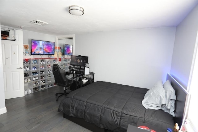 bedroom with a closet, visible vents, and wood finished floors