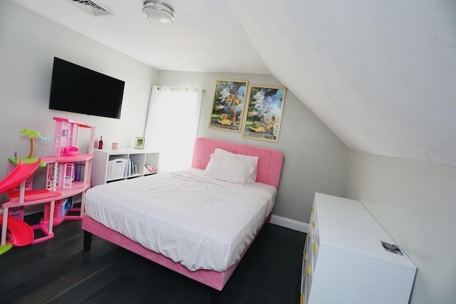 bedroom featuring baseboards, visible vents, vaulted ceiling, and wood finished floors