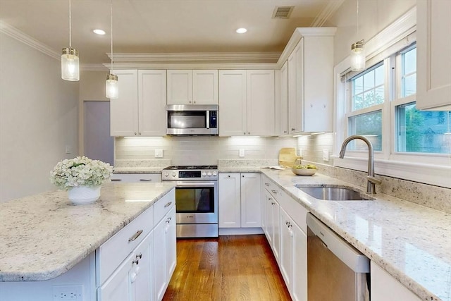 30 Pembroke St, Somerville, MA 02145 - kitchen with appliances with stainless steel finishes, a sink, crown molding, white cabinets, and dark wood-style floors