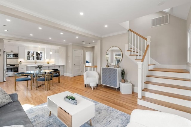 21 Francis St Unit 21, Newton, MA 02459 - living room with stairs, baseboards, light wood finished floors, recessed lighting, and ornamental molding