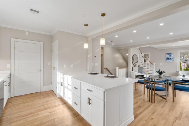 21 Francis St Unit 21, Newton, MA 02459 - kitchen with a peninsula, light wood finished floors, white cabinetry, ornamental molding, and light countertops