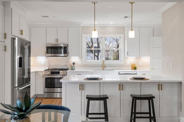 21 Francis St Unit 21, Newton, MA 02459 - kitchen with appliances with stainless steel finishes, a sink, a breakfast bar, a peninsula, and light countertops