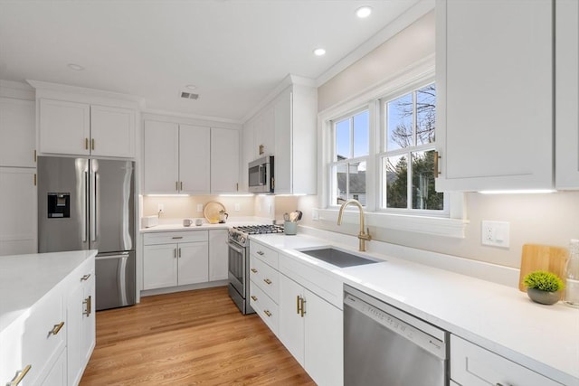 21 Francis St Unit 21, Newton, MA 02459 - kitchen featuring appliances with stainless steel finishes, a sink, light countertops, white cabinetry, and recessed lighting