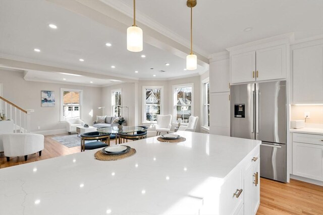21 Francis St Unit 21, Newton, MA 02459 - kitchen with stainless steel fridge with ice dispenser, ornamental molding, open floor plan, white cabinetry, and light wood-style flooring