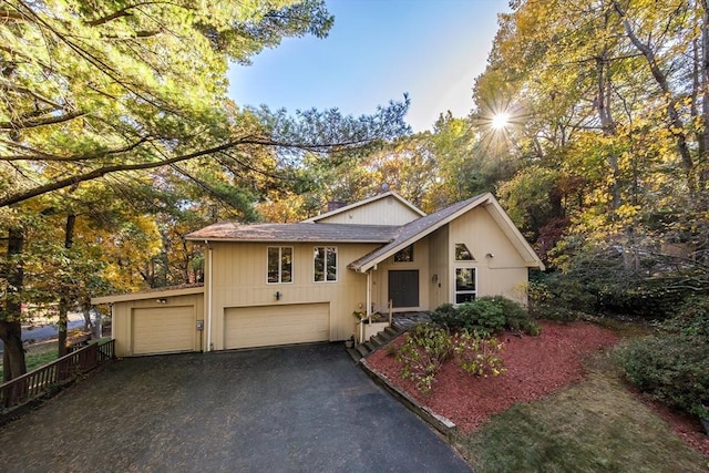 view of front of house featuring a garage, driveway, and a chimney
