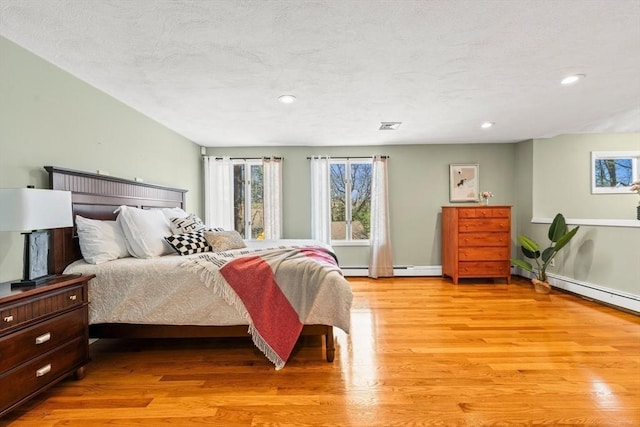 bedroom with visible vents, light wood-type flooring, recessed lighting, and a textured ceiling