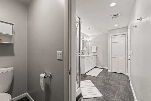 bathroom with vanity, visible vents, baseboards, and toilet