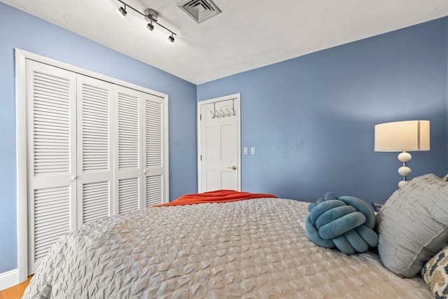 bedroom featuring a closet, baseboards, and visible vents