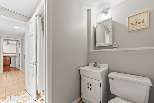 bathroom with vanity, a shower with curtain, tile patterned flooring, toilet, and baseboards