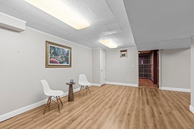 sitting room featuring light wood-style flooring, baseboards, and ornamental molding
