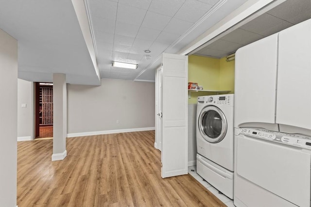 laundry room with baseboards, light wood-style floors, washing machine and dryer, and laundry area