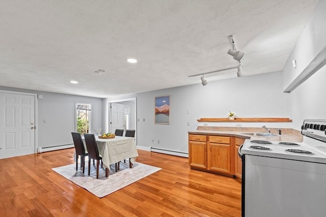 kitchen with baseboard heating, a baseboard heating unit, a sink, light wood finished floors, and electric range oven