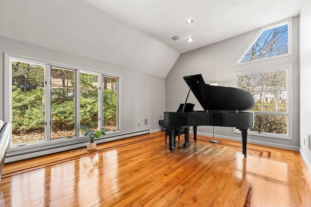 sitting room featuring baseboards, wood finished floors, vaulted ceiling, and baseboard heating