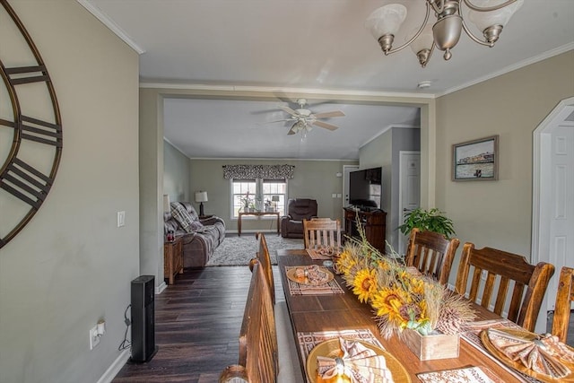 dining room featuring dark hardwood / wood-style flooring, crown molding, and ceiling fan with notable chandelier