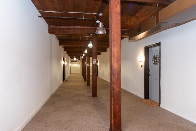 hall featuring wood ceiling, beamed ceiling, baseboards, and carpet floors
