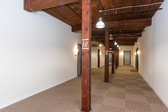 hallway with wooden ceiling, carpet, baseboards, and beamed ceiling