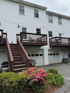 100 E 6th St Unit 2, Dracut, MA 01826 - rear view of property featuring a garage, asphalt driveway, and central air condition unit