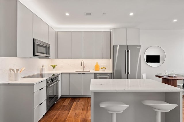 1515 Commonwealth Ave Unit 314, Boston, MA 02135 - kitchen with stainless steel appliances, dark wood-type flooring, decorative backsplash, light stone counters, and recessed lighting