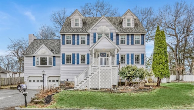 view of front facade featuring a garage, a shingled roof, a front lawn, and fence