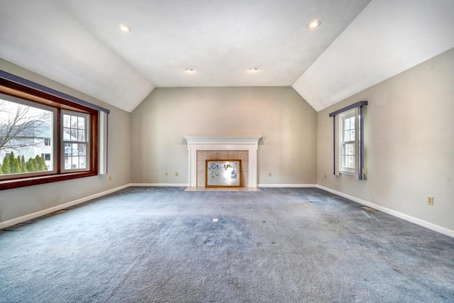 unfurnished living room with a fireplace, carpet, baseboards, and vaulted ceiling