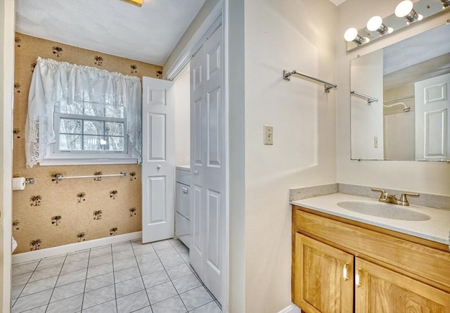 full bath with vanity, baseboards, and tile patterned flooring