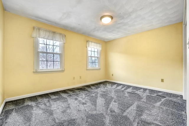 spare room with baseboards and carpet