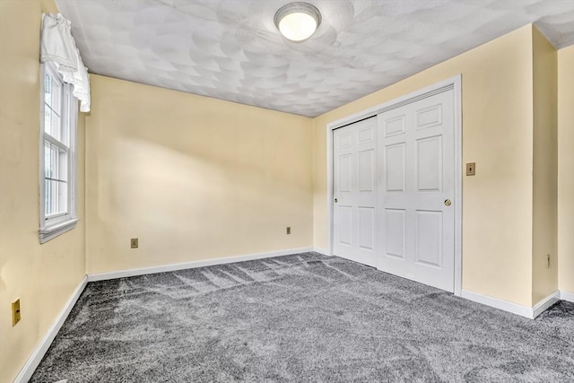 unfurnished bedroom with a closet, baseboards, and carpet floors