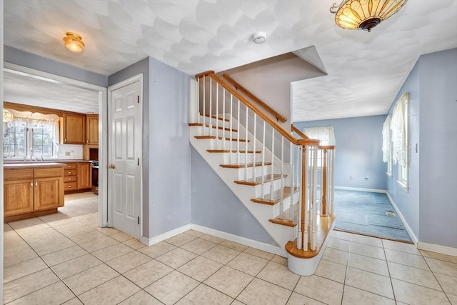 staircase featuring tile patterned floors and baseboards