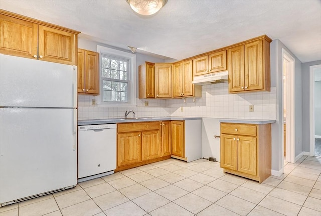 kitchen with under cabinet range hood, light tile patterned floors, backsplash, and white appliances