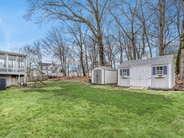 view of yard with an outbuilding, a storage unit, and a sunroom