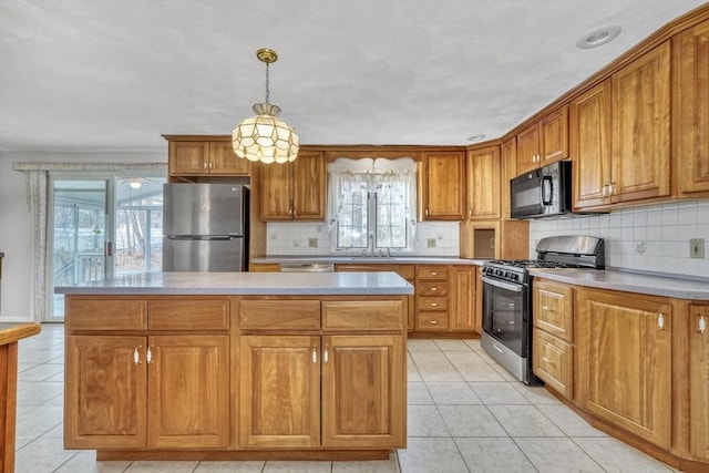 kitchen featuring hanging light fixtures, a kitchen island, brown cabinets, and stainless steel appliances