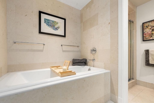 bathroom featuring independent shower and bath, tile patterned flooring, and tile walls