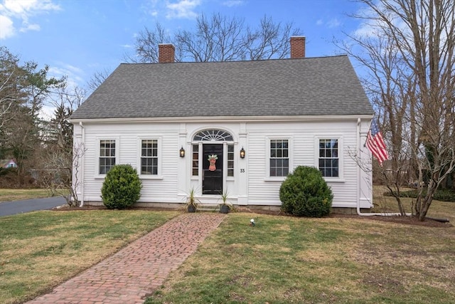 cape cod home with a front lawn