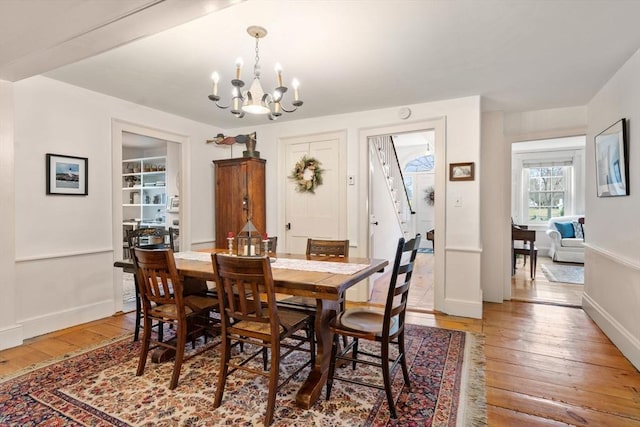 dining room with hardwood / wood-style floors and a notable chandelier