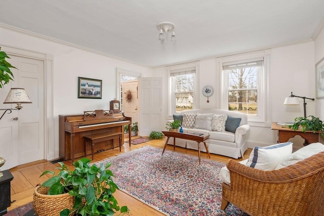 sitting room with hardwood / wood-style floors and ornamental molding