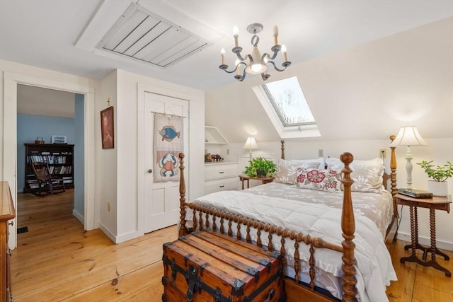 bedroom featuring vaulted ceiling with skylight, an inviting chandelier, and light hardwood / wood-style flooring