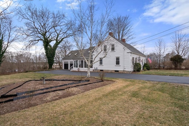 back of house featuring a garage and a lawn