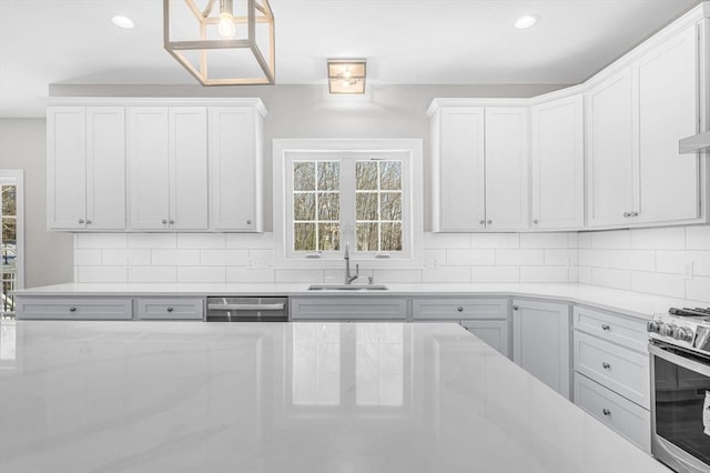 kitchen with decorative backsplash, stainless steel appliances, a sink, and recessed lighting