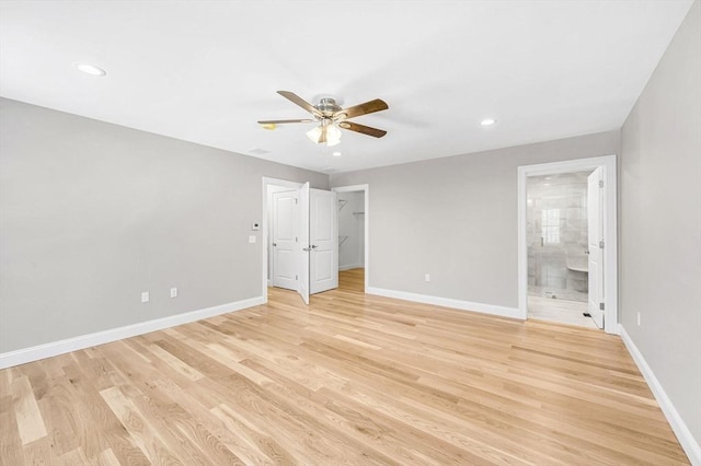 unfurnished bedroom featuring light wood-type flooring, connected bathroom, baseboards, and recessed lighting