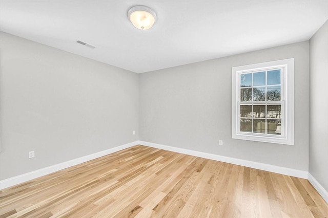 unfurnished room with visible vents, light wood-style flooring, and baseboards