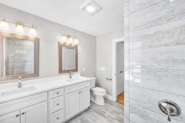 bathroom featuring a sink, toilet, and double vanity