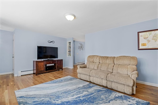 living room with a baseboard radiator and light hardwood / wood-style flooring